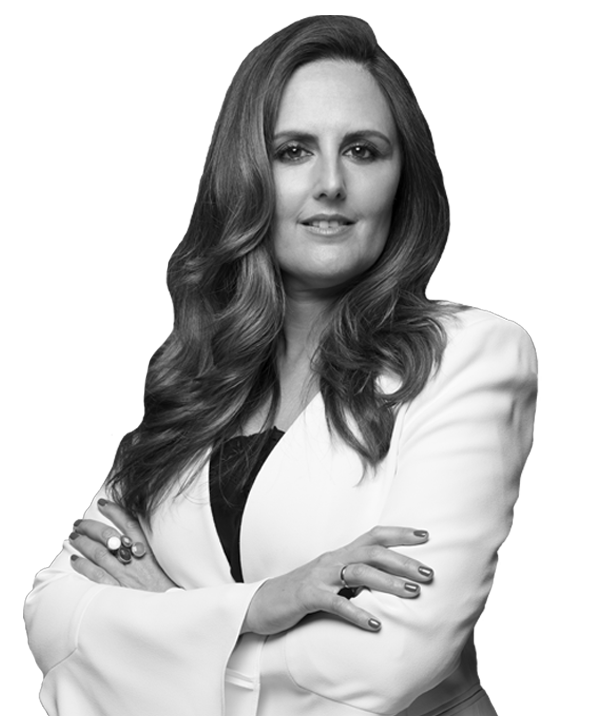 Mujer con abrigo blanco sonriendo con los brazos cruzados.